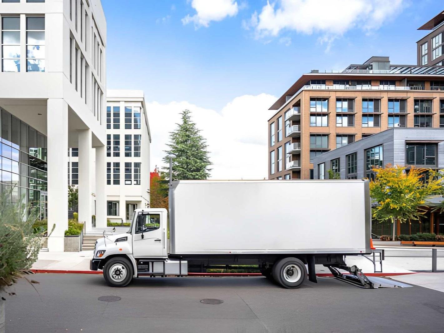 A white moving truck is parked in front 1