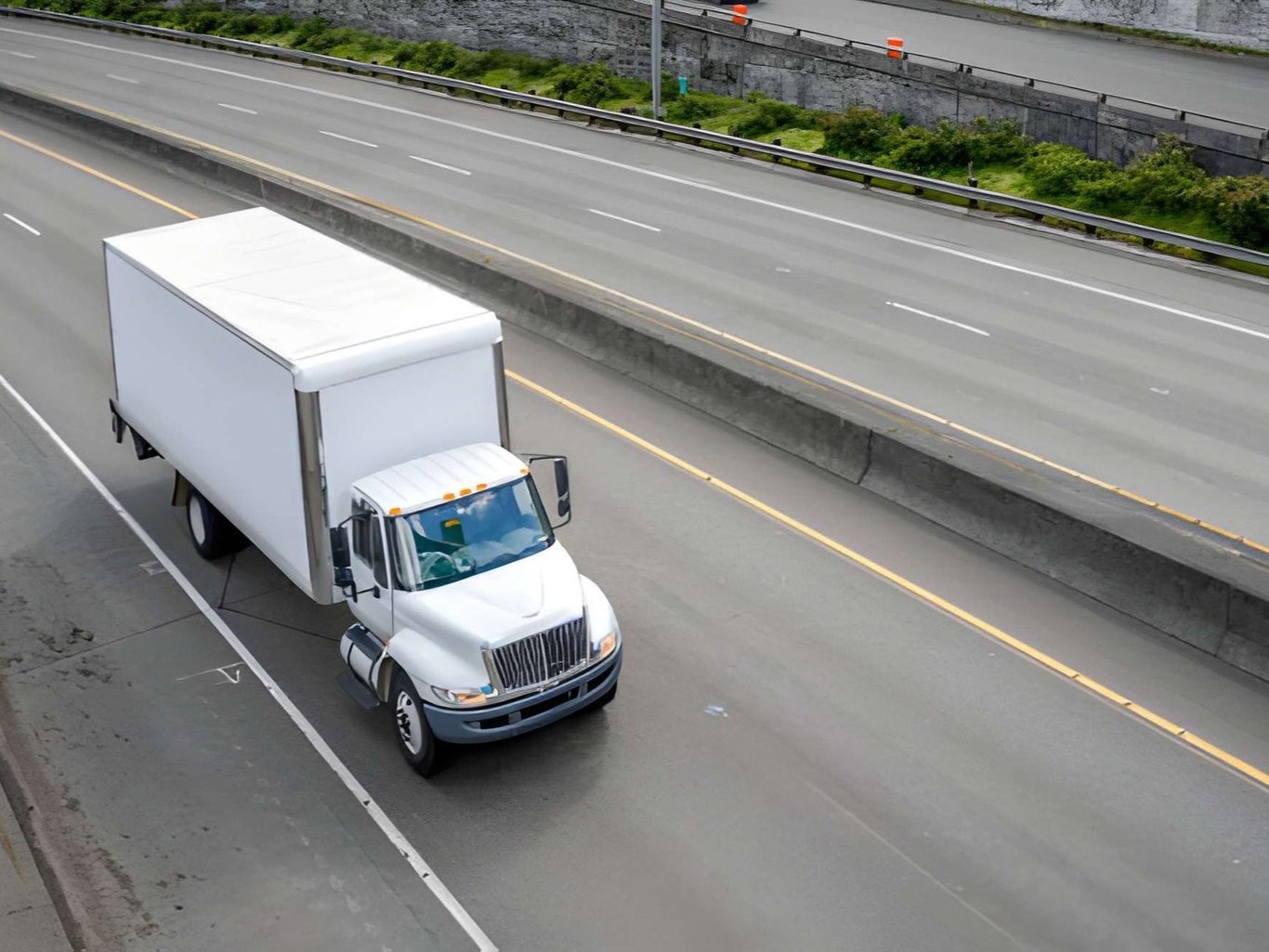 A white truck is driving on a highway