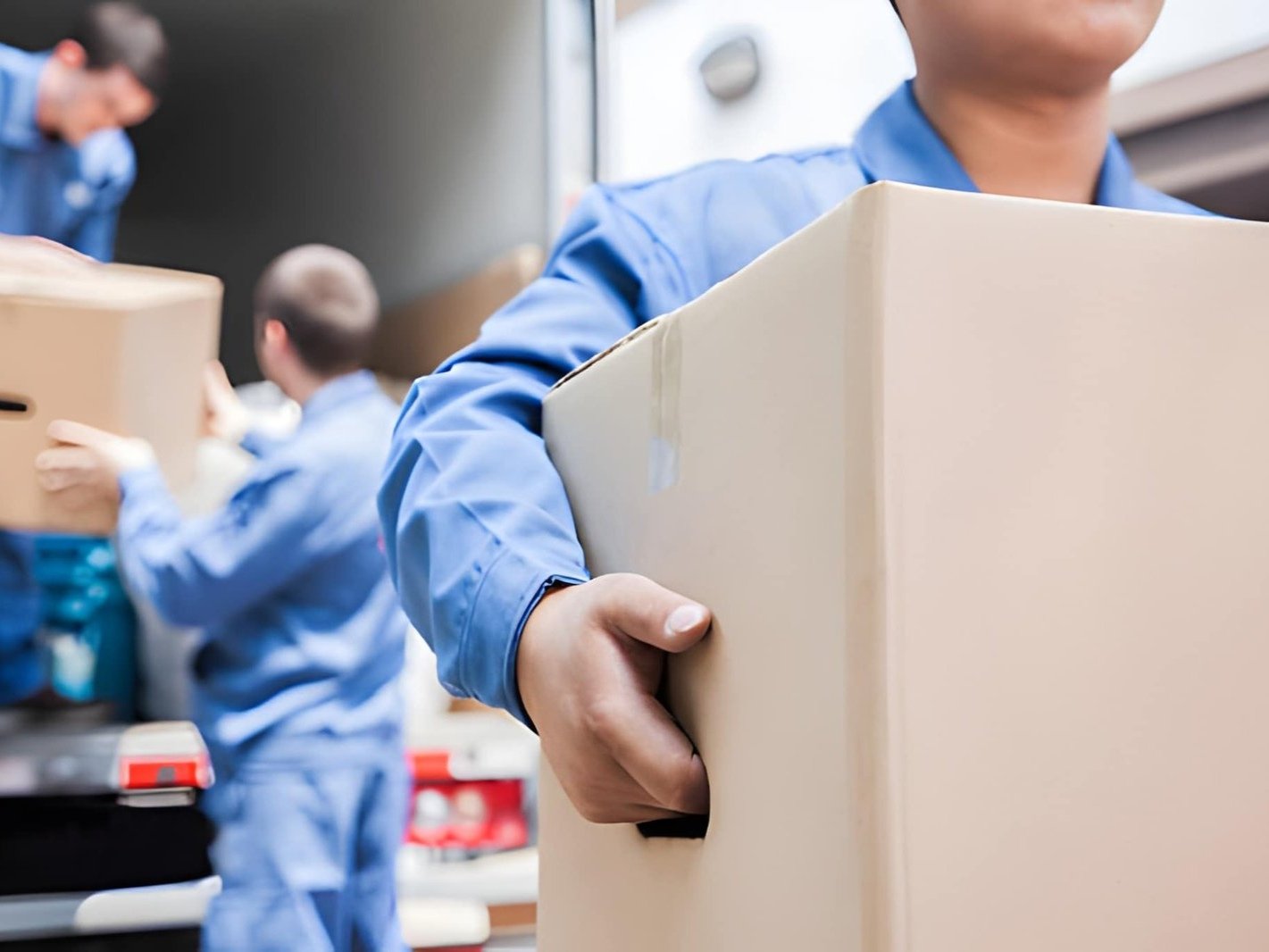 a person carrying a cardboard box, likely during a labor